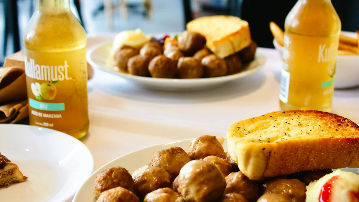 Köttbullar suecas con puré de patata, salsa de carne y mermelada de arándanos rojos